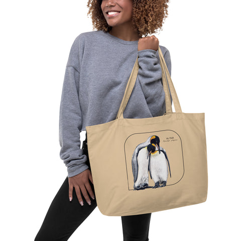 A model holding a product mockup of our large and sturdy tote bag. It comes with a beautiful print of a hand-drawn pair of king penguins huddled together. 100% organic cotton. Beach bag, shopping bag, travel bag, or just as a present.