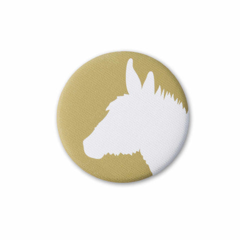 A gold-yellow, fabric-covered magnet with the silhouette of a donkey on a flat white surface.