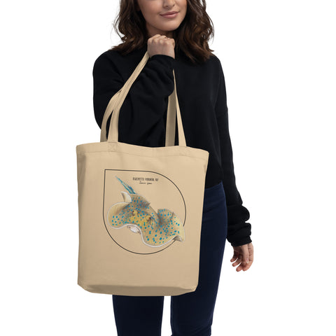 Mock-up of our Bluespotted ribbontail ray tote bag on a model. made from 100% organic cotton.