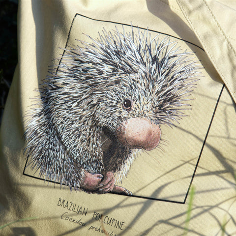 Tote bag with print of a Brazilian porcupine. Beautiful print of hand-drawn animal, 100% organic cotton. Beach bag, shopping bag, travel bag, or just as a present. Here shown in a close-up in a real-life setting.