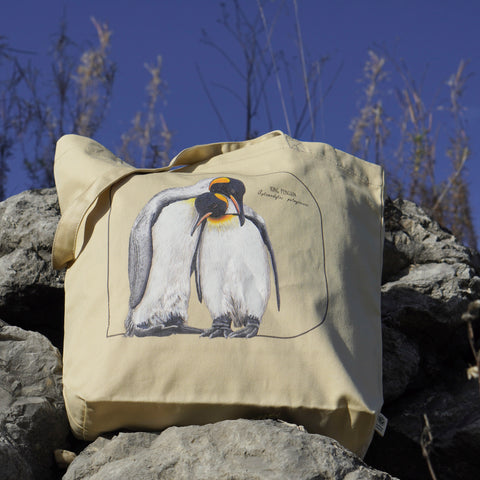 Outside photo of our sturdy tote bag. It comes with a beautiful print of a hand-drawn pair of king penguins huddled together. 100% organic cotton. Beach bag, shopping bag, travel bag, or just as a present.