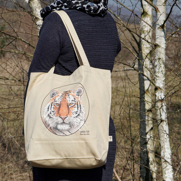Model carrying the organic cotton tote bag with a striking siberian tiger print.