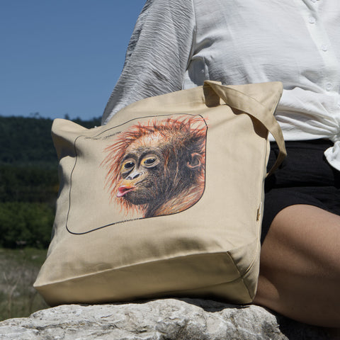 Outside product photo of the sumatran orangutan organic tote bag next to a sitting model.