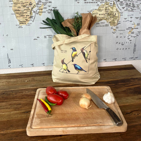 Standard size organic tote bag with a lively print of 4 variable sunbirds. Here in use with a bunch of groceries. Perfect reusable shopping bag!