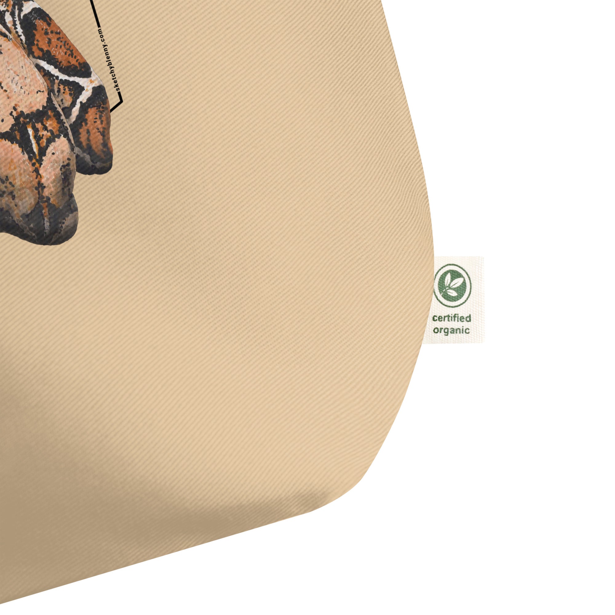 Product mockup of our organic tote bag with a boa constrictor print, shown here is a detail of the organic logo.