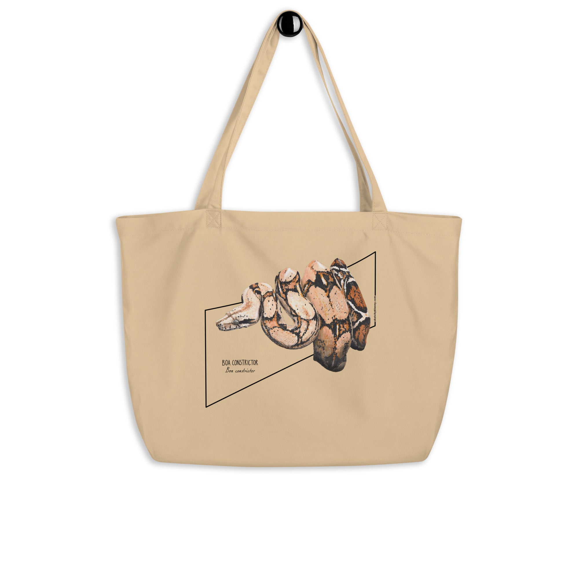 Product mockup of our organic tote bag with a boa constrictor print, hanging from the handles.