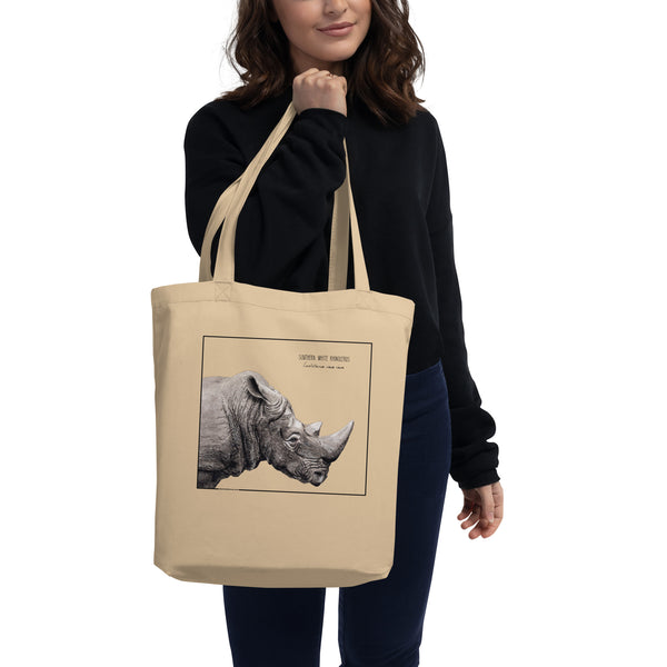 Product mockup of our tote bag with beautiful, carefully drawn southern white rhinoceros printed on the front side of the bag. Here shown being held by a model