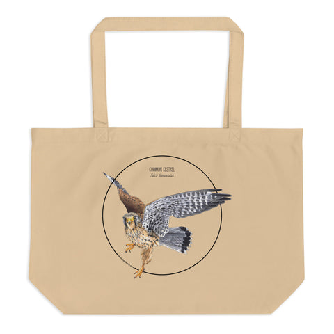 Product mockup of the large organic tote bag featuring a kestrel print. Here lying on a flat white surface.