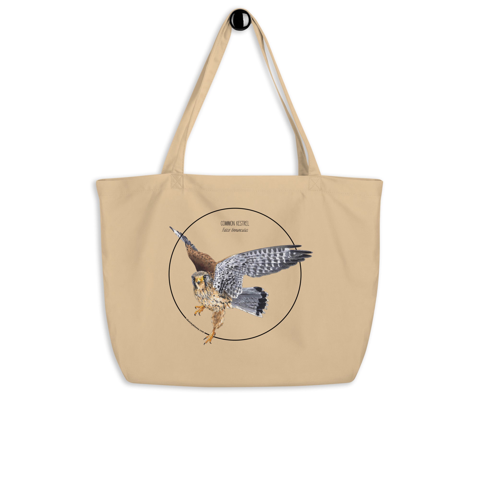Product mockup of the large organic tote bag featuring a kestrel print. Here hanging from a hanger.