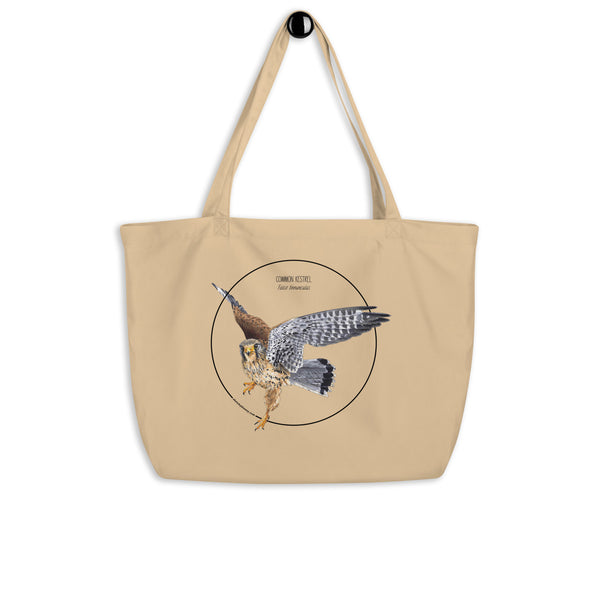Product mockup of the large organic tote bag featuring a kestrel print. Here hanging from a hanger.