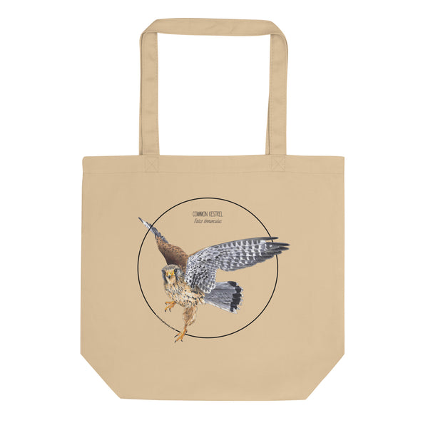 Product mockup of the organic tote bag featuring a kestrel print. Here lying on a flat white surface.