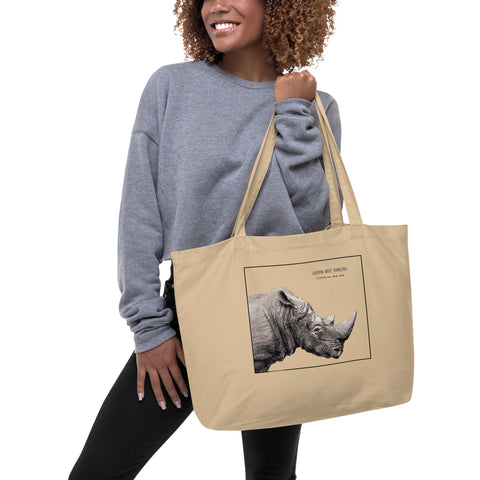 Product mockup of our tote bag with beautiful, carefully drawn southern white rhinoceros printed on the front side of the bag. Here being held by a model.