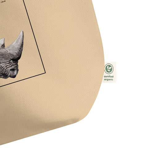 Product mockup of our tote bag with beautiful, carefully drawn southern white rhinoceros printed on the front side of the bag. Detail of the certified organic label.