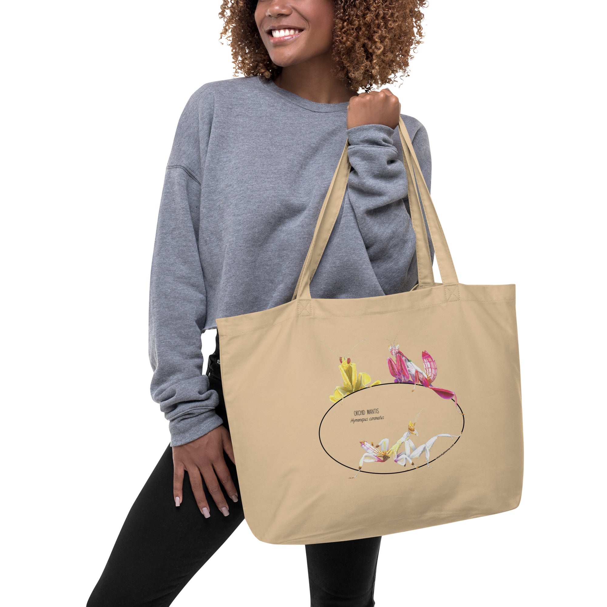 Mock-up of our large size Orchid mantis tote bag, hanging from the hands of a model.  100%organic cotton, sturdy and spacious