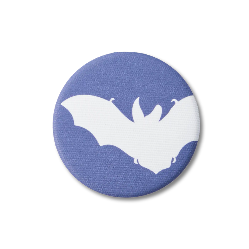 A navy-blue, fabric-covered magnet with the silhouette of a Brown Long-Eared Bat lies on a flat white surface.