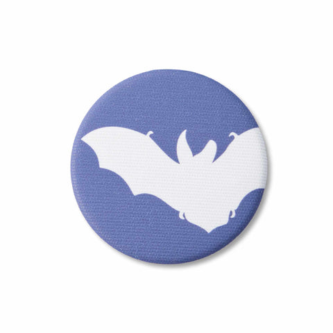 A navy-blue, fabric-covered magnet with the silhouette of a Brown Long-Eared Bat lies on a flat white surface.