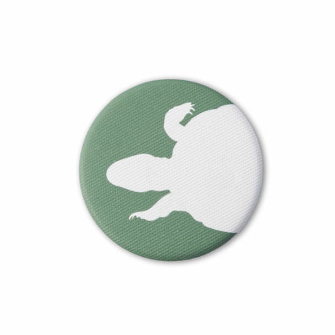 Green fabric-covered magnet with the white silhouette of a swimming turtle from above.