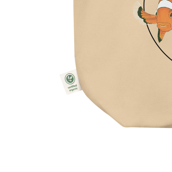 Product mockup of our organic tote bag featuring a print of 3 hand-drawn common clownfishes. Here a detailof the organic label.
