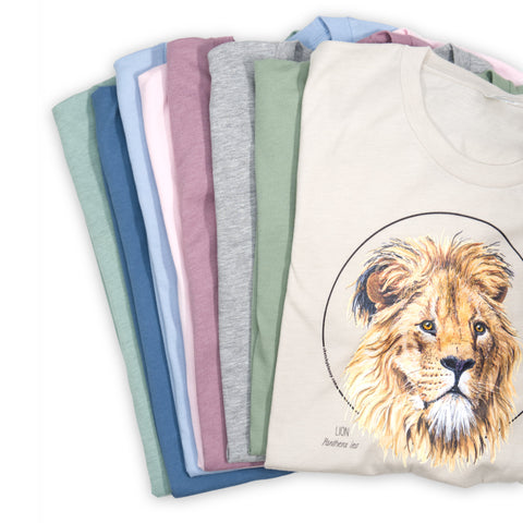 Photo of all available t-shirt colours, all shirts folded on a white surface.