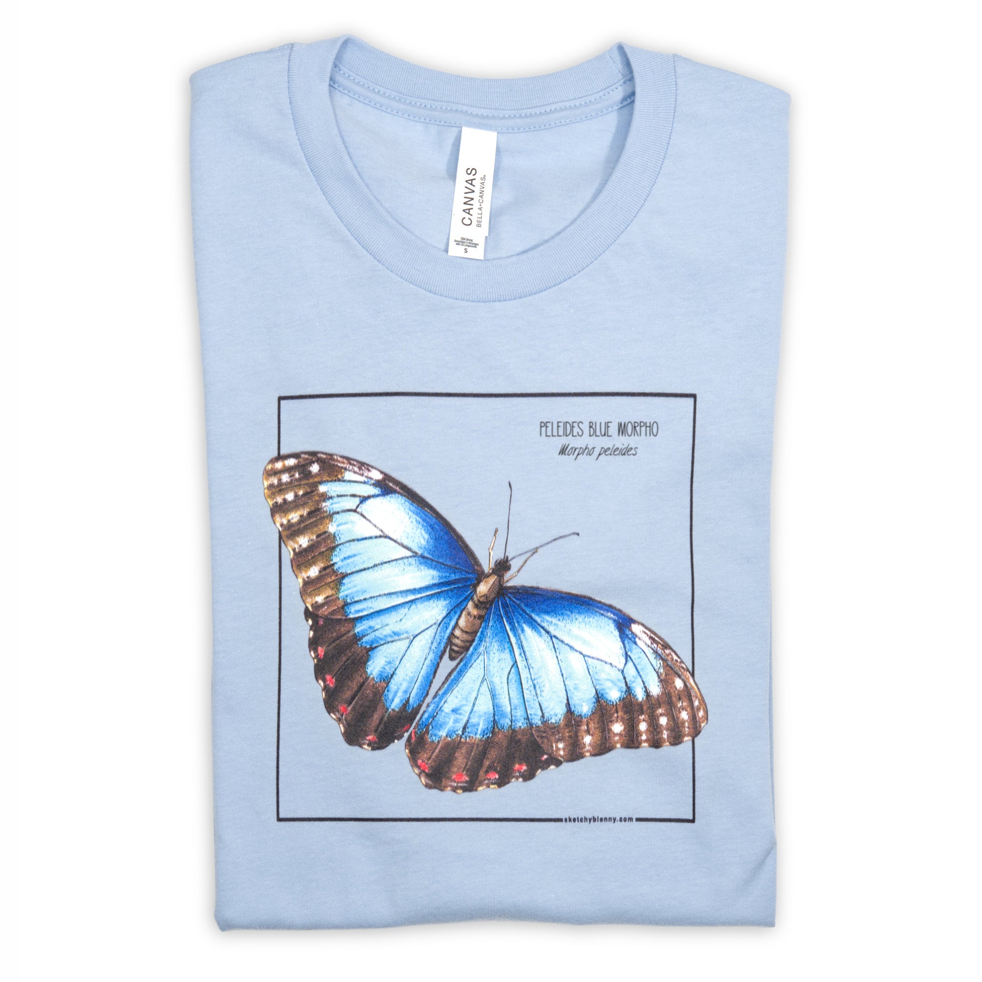 Photo of our baby blue blue morpho butterfly t-shirt folded on a white surface.