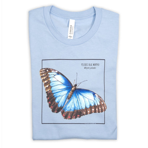 Photo of our baby blue blue morpho butterfly t-shirt folded on a white surface.