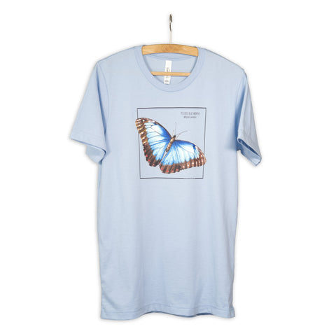 Photo of our baby blue blue morpho butterfly t-shirt hanging from a wooden hanger.