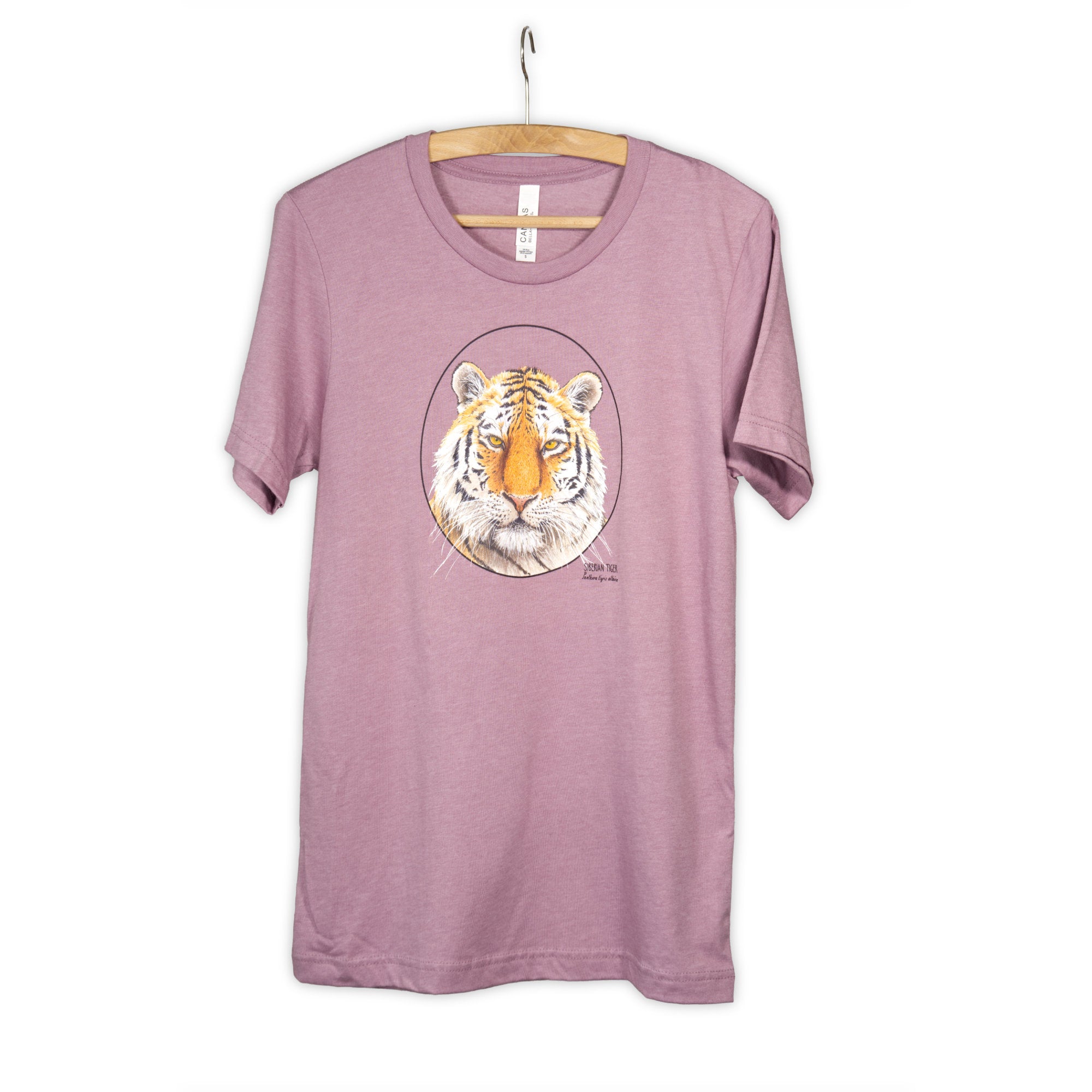Photo of our t-shirt with a siberian tiger print on a heather orchid coloured fabric. Hanging from a wooden hanger.